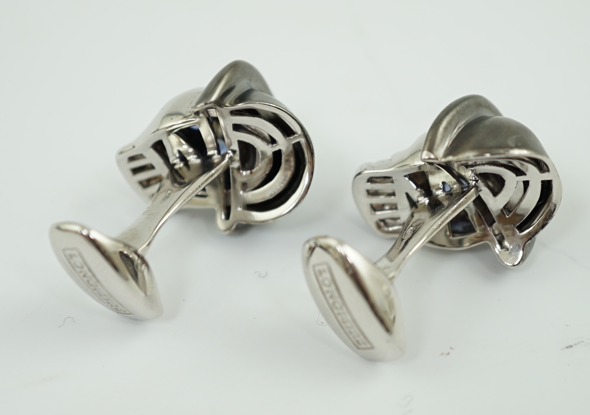 A modern pair of Longmire 18ct white gold, blackened rhodium and sapphire set novelty cufflinks, each modelled as a skull wearing a bowler hat